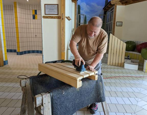 Sven Großer-Friedrich, Mitarbeiter im LIMBOmar schleift das Holz der Liegeflächen aus der Sauna wieder glatt.