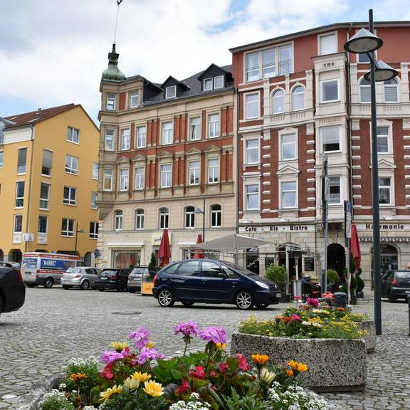 Johannisplatz mit Blumen, Autos und Jugendlichen